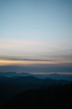 Bask Ülkesi 'nde gün batımında bulutların üzerinde uçan uçak.