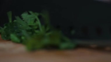 Ev mutfağında yemek yapmaya yakın çekim. Tahtadaki adam sağlıklı diyet salatası için taze otları bıçakla kesiyor. Lezzetli bir öğle ya da akşam yemeği için sebze malzemeleri hazırlıyorum..