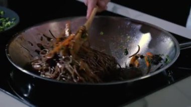 Asya mutfağının tarifine göre tavada taze sebzeli erişte pişirmek..