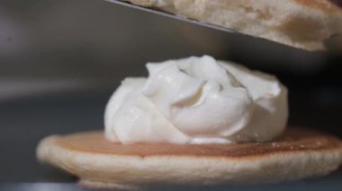Pişirme gözlemesine yakın çekim. Çırpılmış hamur pişirmek lezzetli bir tatlıdır. Aşçı beyaz kremalı tortilla yığınına krep koyar. Pasta dükkanında tatlı hamur işleri. Kahvaltıda tatlı. Günaydın.