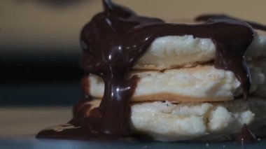 Pişirme krepinin yakın çekimi. Çırpılmış hamur pişirmek lezzetli bir tatlıdır. Aşçı tatlıya sıcak çikolata ve böğürtlen şurubu döker. Kahvaltıda kremalı ve çikolatalı taze krep.
