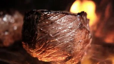 Izgarada yanan kömürde sulu bir biftek kızartıyorum. Izgarada şeritli sulu biftek, piknik kutlaması için hazır. Barbekü ızgarası dışarıda