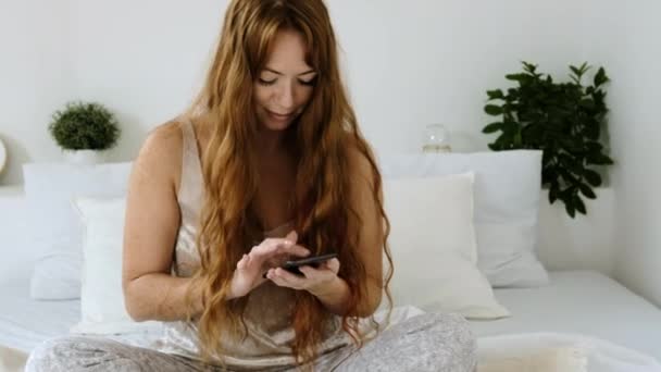 Νεαρή Γυναίκα Άσπρες Πιτζάμες Μακριά Κόκκινα Μαλλιά Κάθεται Πρωί Αφού — Αρχείο Βίντεο