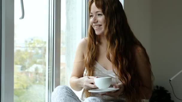 Портрет Счастливой Женщины Пьющей Горячий Кофе Сидящей Подоконнике Большого Окна — стоковое видео
