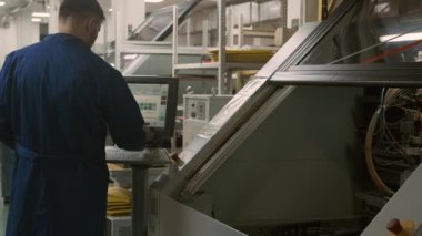 Modern robotik üretim operatörü yüksek teknolojili ekipmanlar üzerinde çalışıyor. Büyük otomatik makineyi kontrol eden kişi, veriyi programa dahil eder. Yüksek hassasiyetli teknolojilerin dijital endüstrisi