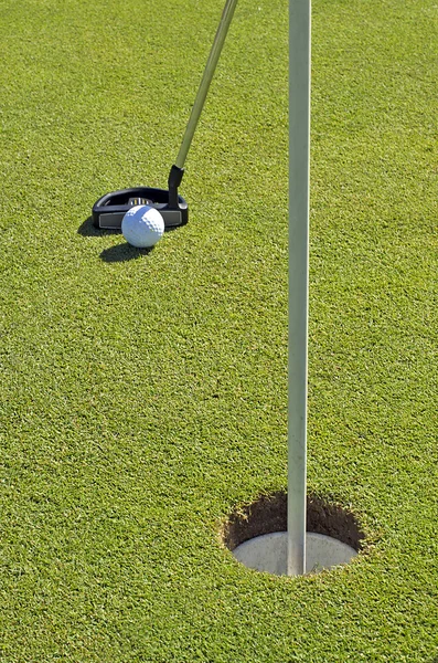 Мяч для гольфа и лунка — стоковое фото