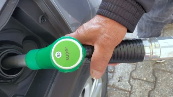 Man bij tankstation tijdens het tanken van een auto, verhoging van de benzinekosten concept — Stockvideo