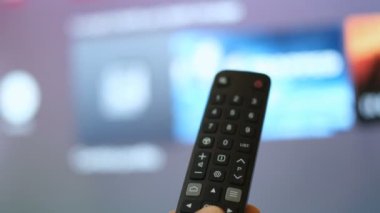 Erkek adam akıllı TV uygulamalarına el gezer, eğlence tecrit saatinde zaplama kanalları, ev yaşam tarzı