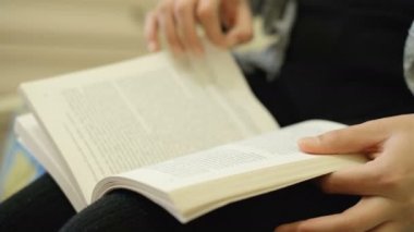 Boş zamanlarında kitap okuyan, bilgi sahibi olan, kilit altında olan, yaşam tarzını rahatlatan bir kadın.
