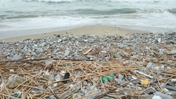 Poluição do lixo de detritos plásticos descartados após tempestade de ondas do mar, resíduos da natureza ambiental — Vídeo de Stock