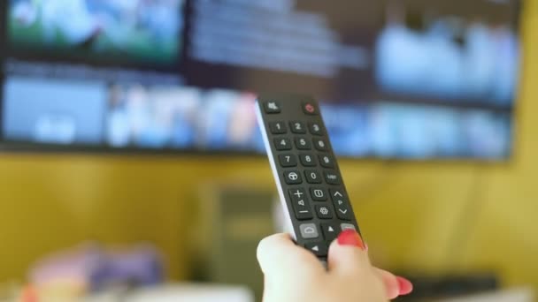 Genç bir kadın akıllı TV uygulamasına göz atıyor, boş zamanlarında kanalları zaplıyor, ev teknolojisi yaşam tarzı... — Stok video