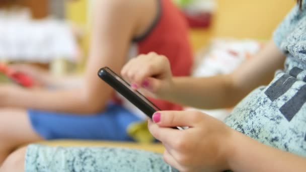 子供の女の子は 家庭の余暇時間にスマートフォンを使用し 子供の教育技術中毒 — ストック動画