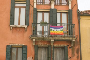Rainbow peace flag exposed on city house facade to support stop war in Ukraine..