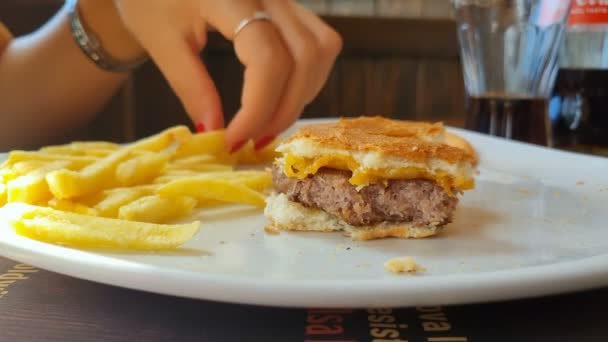 Tânără Mănâncă Cartofi Prăjiți Hamburger Într Restaurant Fast Food Mâncare — Videoclip de stoc