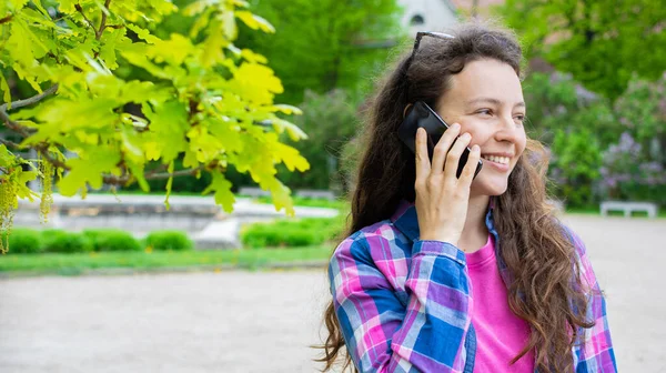Güzel bir genç kadının telefonda kişisel konuşması, hafta sonu arkadaşınla buluşma planı ayarlaması, yeşil bahçede konuşmanın keyfini çıkarması, uzaktan iletişim kurması. Boşluğu kopyala.