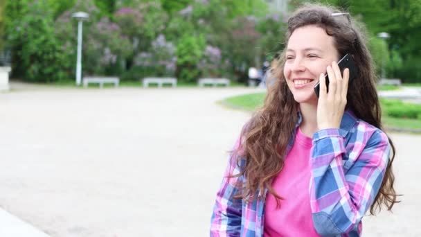 Молода Щаслива Кучерява Брюнетка Яка Посміхається Говорити Мобільному Телефону Стоїть — стокове відео