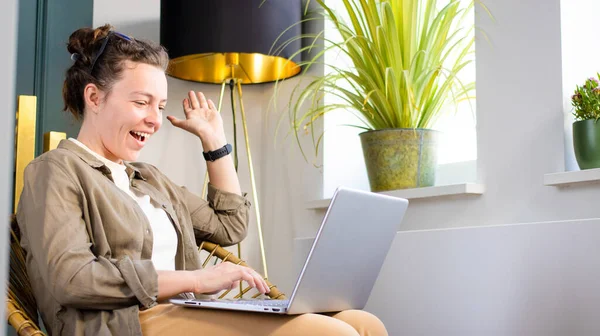 Excited brunette girl looking at laptop surprised by good unbelievable news, feeling amazed, sitting in modern home interior indoor.Good news,great result, lottery win,new opportunity, getting new job