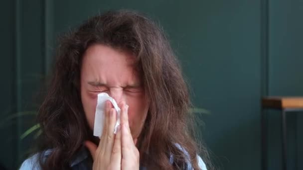 紙ナプキンに若いブルネットの女性のくしゃみ 鼻を実行して吹いて呼吸支援不快感を減少させ 自宅でベッドに座っている 花粉症 鼻粘膜炎 ウイルス感染症 — ストック動画