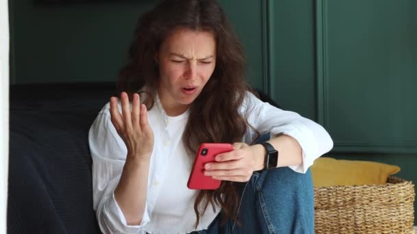 Mutsuz Stresli Beyaz Bir Kadın Akıllı Telefona Bakıyor Oturma Odasında — Stok video