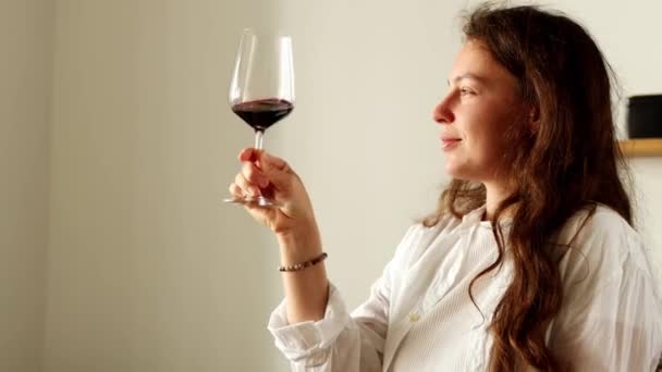 Curly Brunette Girl Holding Wineglass Sniffing Red Wine Smelling Enjoying — Vídeo de stock