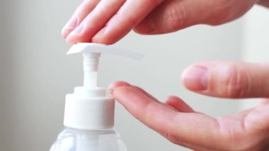 Kadın ilaç ve antibakteriyel sıvı sabun ya da antiseptik sıkarak beyaz odanın arka planına yakın çekim yapıyor. Banyoda el yıkamak, gelişmiş cilt bakımı için yumuşak jel kullanmak.. 