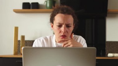 Shocked upset millennial woman looking at laptop received bank account balance email, feeling frustrated by unexpected unhappy news sit at home office. Getting low exam result or bad financial report.