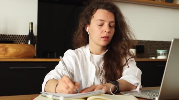 Focused Young Woman Headphones Writing Notes Using Laptop Online Education — Vídeo de Stock
