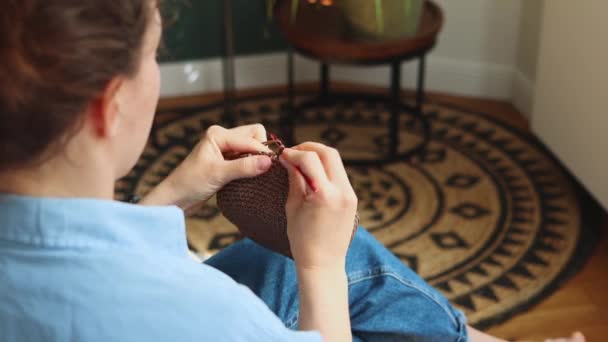 Πίσω Πλευρά Νεαρή Γυναίκα Crocheting Καφέ Τσάντα Χρησιμοποιώντας Ροζ Γάντζο — Αρχείο Βίντεο