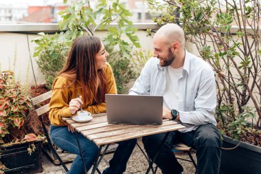 Kafedeki gençler kablosuz internet teknolojisini kullanıyorlar - bilgisayar kullanan Kafkasyalı arkadaşlar - öğrenciler veya serbest çalışanlar 