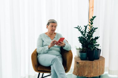 Cep telefonuyla mesajlaşan yaşlı kadın - üçüncü çağ yaşam tarzı teknolojisi