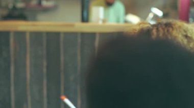 Asyalı bir kadın meslektaşlarıyla masaya gülüyor. Doğu öğrencisi diğer öğrencilerin kafesiyle eğleniyor.