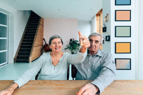 Mutlu Yaşlı Çift Masada Oturmuş Anahtarlarını Tutuyorlar — Stok fotoğraf