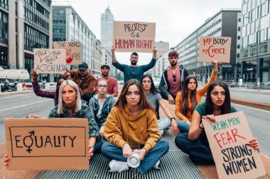 Kadın hakları ve cinsiyet eşitliği yürüyüşünde protesto pankartları taşıyan bir grup genç