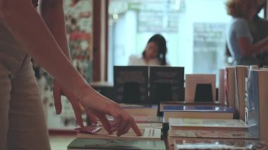 Kız kütüphane dükkanından bir kitap seçiyor - detaylar hazır.