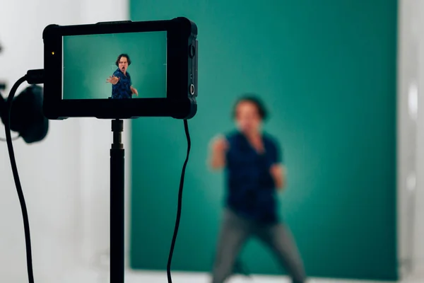 テレビ放送を記録している間のタッチスクリーンカメラの焦点 緑の背景に映画のランニングコンセプト — ストック写真