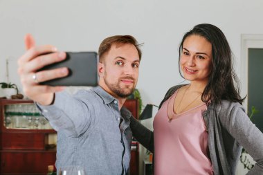 Çift evde akıllı telefonuyla selfie çekiyor. Sosyal ağda paylaşıyorlar.
