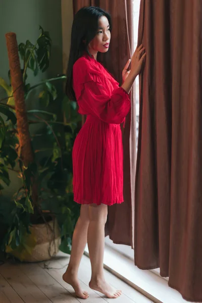 Mulher Asiática Vestido Vermelho Pés Nus Quarto Olha Para Fora — Fotografia de Stock