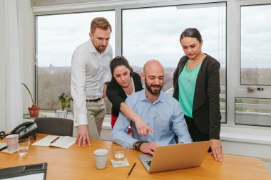 Ofiste dizüstü bilgisayarla çalışan bir grup insan - birlikte çalışan çalışanlardan oluşan bir ekip ya da iş arkadaşları