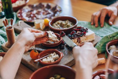 Peyniri krakere reçel sürüyorum.