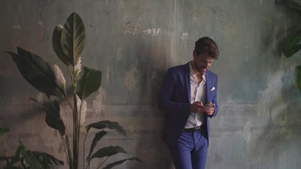 Νεαρός Κομψός Άντρας Μπλε Κοστούμι Χρησιμοποιώντας Κινητό Τηλέφωνο Επιχειρηματίας Ακουμπισμένος — Αρχείο Βίντεο