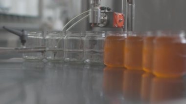 industrial machine in honey production filling jars of honey