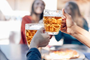 İnsanlar eğlence ve dostluk kutlaması konsepti. Mutlu arkadaşlar. Partide bira içip kadeh tokuşturuyorlar.