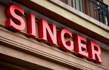 Bükreş, Romanya - 08 Nisan 2021: Amerikan tüketici dikiş makinesi üreticisinin Singer Corporation logosu Bükreş 'teki genel merkezinin üzerinde görülüyor.