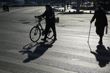Bükreş, Romanya - 26 Kasım 2021: Romanya 'nın Bükreş kentinde insanlar karşıdan karşıya geçiyor. Bu resim sadece editörler içindir..