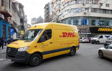 Bükreş, Romanya - 24 Şubat 2022 Bükreş 'te bir sokakta sarı bir DHL teslimatı. Bu resim sadece editörler içindir..