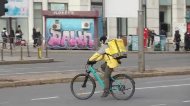 Bükreş, Romanya - 08 Mart 2022: Bir Glovo gıda dağıtım kuryesi Romanya 'nın Bükreş kentinde gıda dağıtıyor.