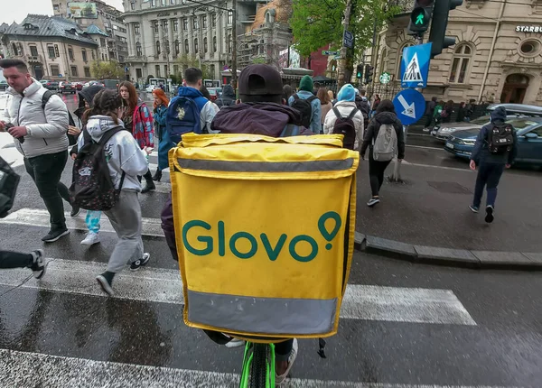 Bükreş, Romanya - 11 Nisan 2022: Bir Glovo gıda dağıtım kuryesi Romanya 'nın Bükreş kentinde gıda dağıtıyor.