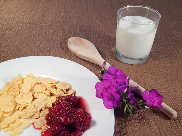 Cornflakes, cherry jam en bloemen, houten lepel — Stockfoto