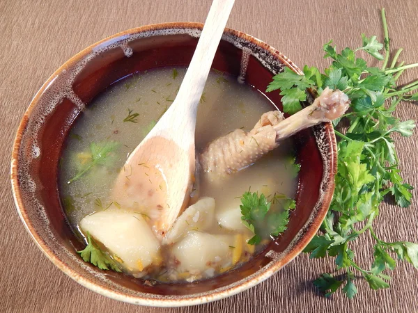 Buckwheat soup with chicken in an earthenware dish, parsley, wooden spoon — Stock Photo, Image