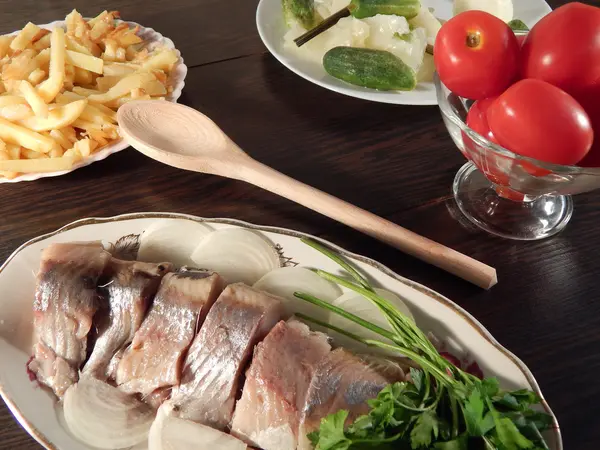 Ringa balığı, patates kızartması, turşu, domates, lahana turşusu, ahşap masa — Stok fotoğraf